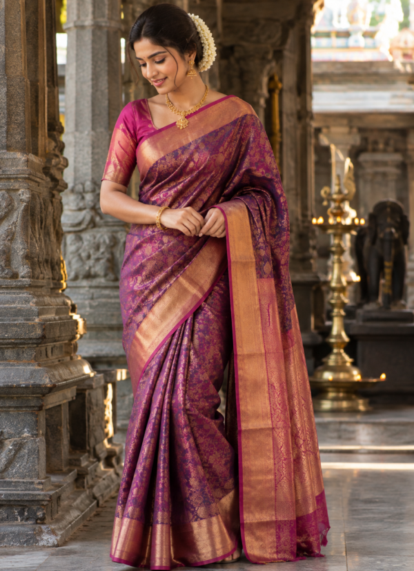 Woman in a purple and magenta Kanchipuram silk saree with a gold zari border